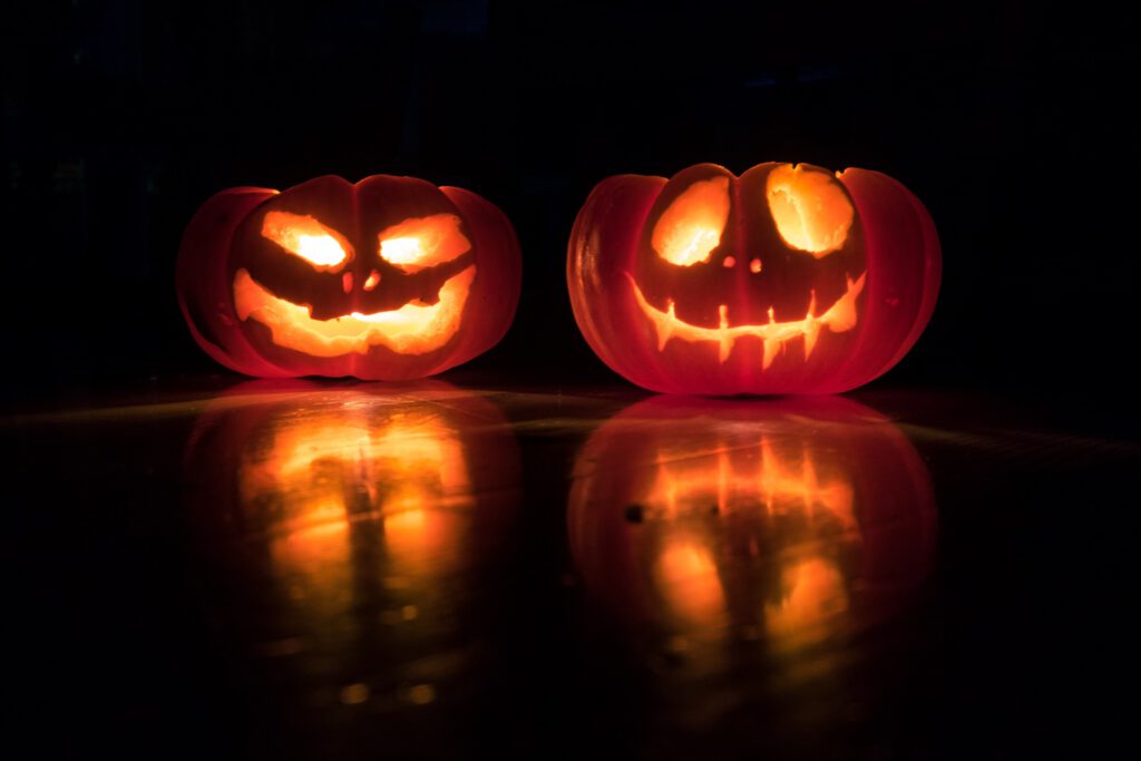 Kürbis Gesichter in Dunkelheit - Du möchtest eine Halloween Party planen? So geht's!